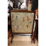 An Edwardian mahogany fire screen, incorporating a silk embroidered panel depicting floral patterns,