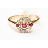 An Art Deco style ruby and diamond ring, set with three rubies with a halo of diamonds, 18ct gold,