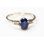 A sapphire and platinum ring, oval central sapphire approx 1.