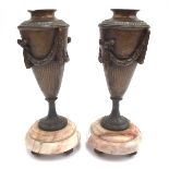 A pair of spelter urns on marble stands,