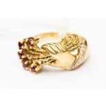 A ruby and diamond set 14ct gold dress ring in the form of a hand holding a bouquet of flowers,