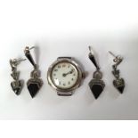 A silver ladies watch (no strap) with two pairs of white metal earrings,