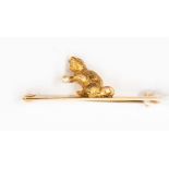 A gold cat brooch, with cat holding a ball of wool, being a pearl, diamond set eyes,