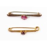 Two bar brooches one in 9ct gold with pink stones, the other in , possibly 15ct gold,