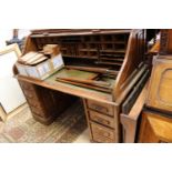 An early 20th Century oak twin pedestal tambour desk, the tambour enclosing pigeon holes,