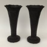 A pair of Wedgwood black basalt trumpet vases: having raised Art Deco design.