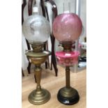 A brass oil lamp with pink reservoir,