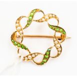 A green demantoid garnet and seed pearl brooch, in the form of a round ribbon,