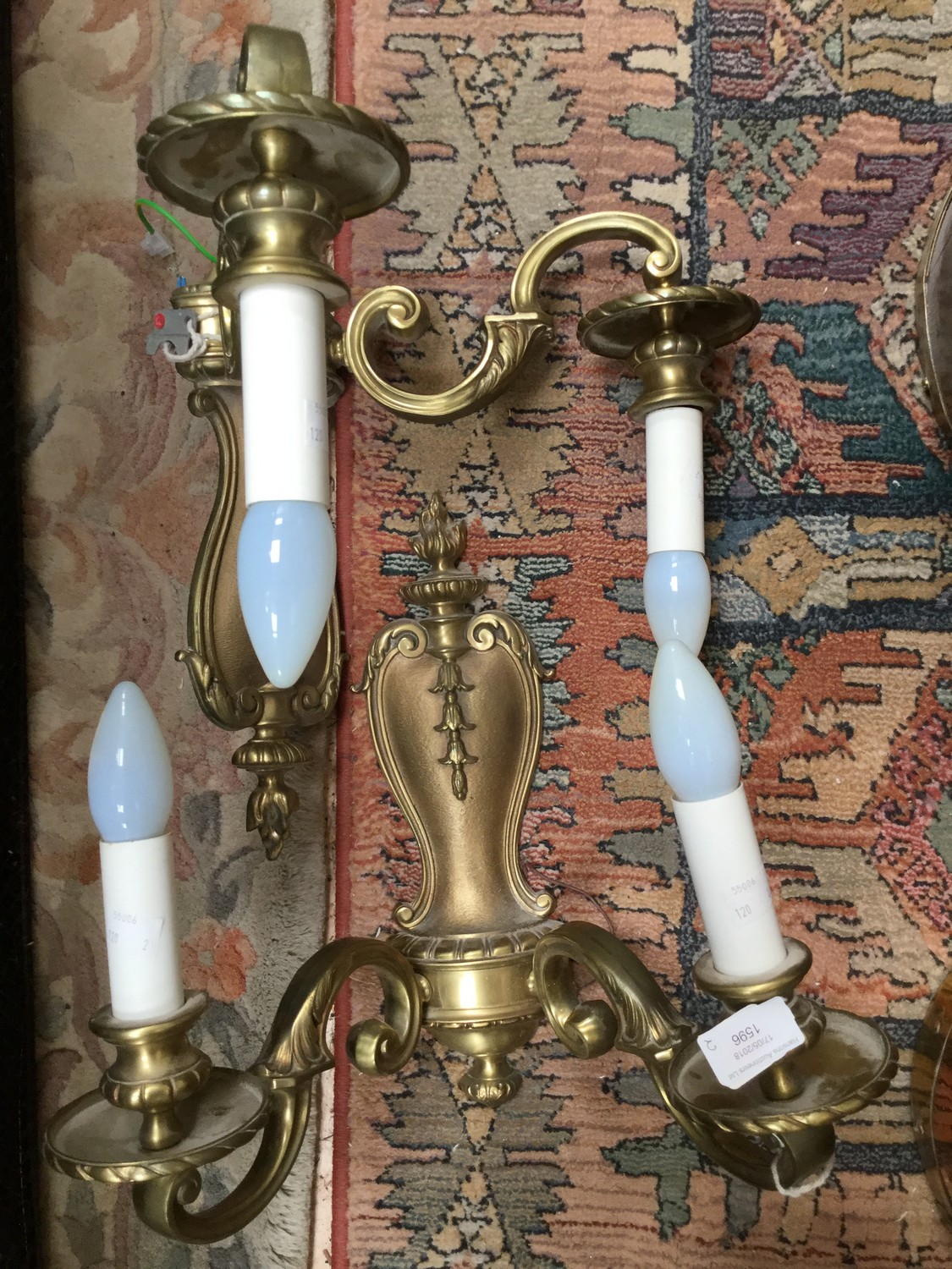 A pair of brass wall light fittings with candle style bulb holders (2)