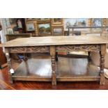 A Jacobean style joined oak low table, the top raised on six turned supports, carved friezes,