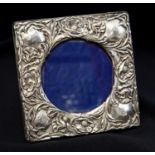 An Arts and Crafts silver photo frame, embossed with poppies and foliage,