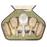 An Arts and Crafts silver six piece brush and mirror set,