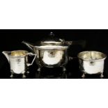 Albert Edward Jones, an Arts and Crafts silver three piece tea set,