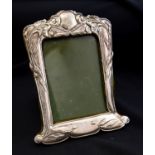 An Arts and Crafts silver photo frame, embossed with foliate design in the Art Nouveau style,