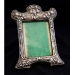 An Arts and Crafts silver photo frame, embossed with fruiting vines in the Art Nouveau style,