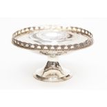 A George V silver circular bowl on stand, open work anthemion border on trumpet foot, London 1927,