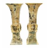 A pair of Chinese patinated green jade trumpet beaker vases (feng gu),