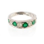 An 18ct white gold, diamond and emerald half eternity ring,