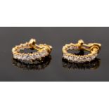 A pair of 18ct yellow gold half hoop earrings, claw set with eight graduated brilliant cut diamonds,