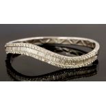 A diamond and white gold hinged bangle, unmarked,