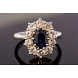 A sapphire and diamond oval cluster 18ct white gold ring, the centre oval blue sapphire approx 1.