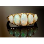 An Edwardian diamond and opal set ring, comprising five graduated oval cabochon opals,