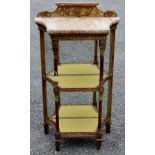 A late 19th Century giltwood carved three tier shelving unit, marble topped, having a mirrored back,