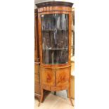 A late 19th Century mahogany bowfront strung standing vitrine, cupboard below, outswept feet,