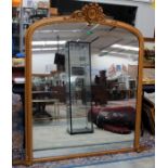 A 19th Century gilt framed overmantle looking glass, having an arched top and finial,