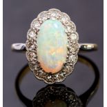 An opal and diamond oval cluster ring, claw set with an elongated oval opal,