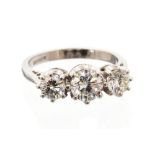 A diamond and 18ct white gold ring, set with three round brilliant cut diamonds,