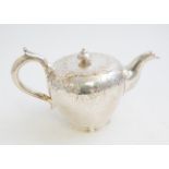 A Victorian silver large teapot, the body engraved with scrolls,