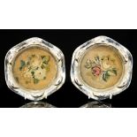 A 18th Century Continental silver coasters, with wavy rims engraved with foliage and chased lobes,