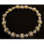 An 18k white and yellow gold and diamond cluster line bracelet,