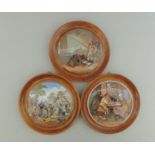 Three Staffordshire Prattware polychrome pot lids, mounted in light wooden frames,