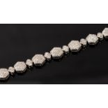 A silver and diamond bracelet, comprising alternate hexagonal and floral links,