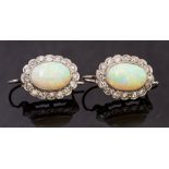 A pair of white metal, opal and diamond earrings, the oval cabachon opal approx 11mm x 8mm,
