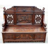 A late 19th Century oak box settle, the crest rail with sunburst centre,