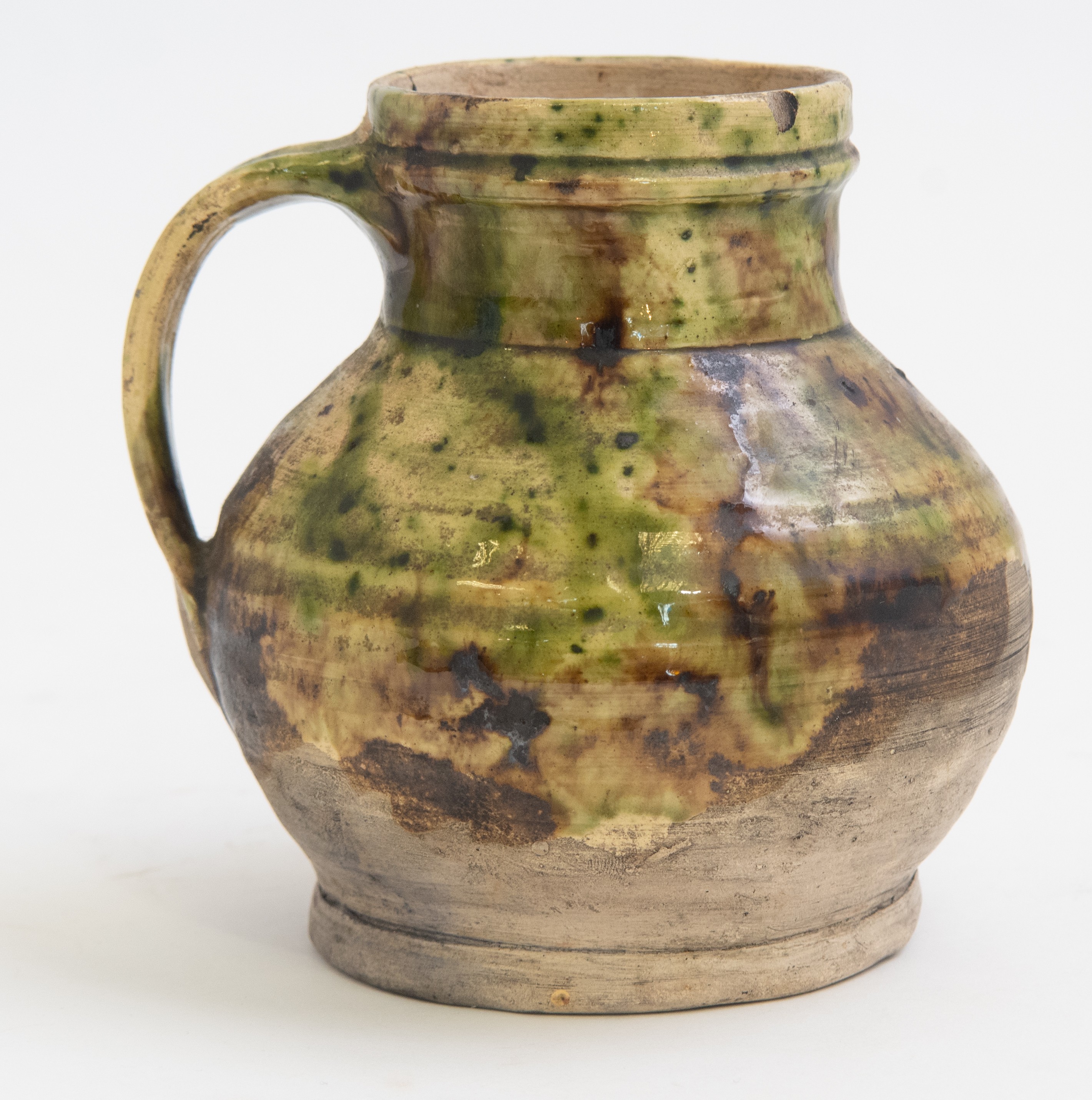 A Medieval pottery ale jug, circa 1380-1450, mottled olive glaze decoration,