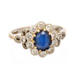 A sapphire and diamond 18ct white gold oval cluster ring, with diamond set shoulders,