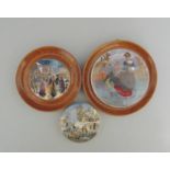 Three Staffordshire Prattware polychrome pot lids, two mounted in light wood frames,