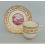 A Derby coffee cup and saucer decorated with gilt borders and central reserve painted in puce of a