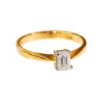 A diamond solitaire ring, set with a claw set emerald cut diamond of approximately 0.