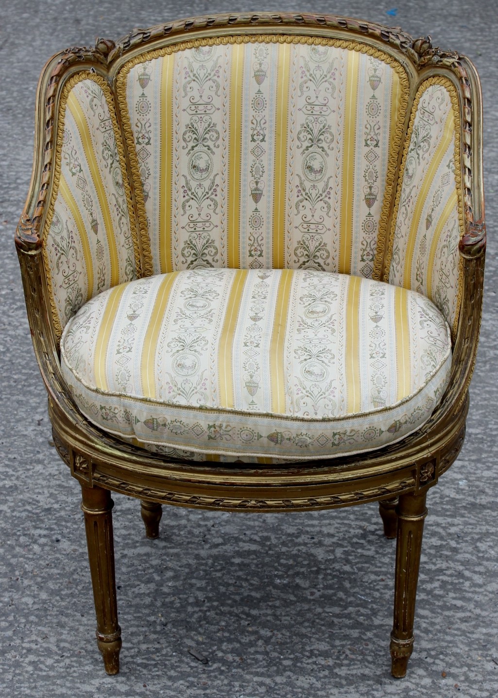 A 19th Century Louis XVI style gilt framed bergere chair, striped upholstery, circular seat,