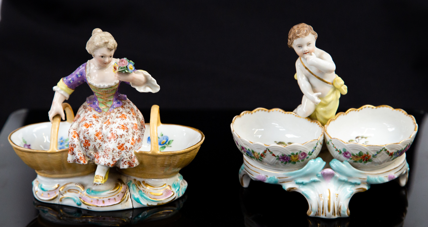 A Berlin porcelain double salt cellar, modelled with a central putto between two floral painted,