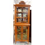 An Edwardian oak corner standing vitrine, circa 1905, glazed doors, mirror back interior,