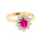 An 18ct yellow gold, ruby and diamond cluster ring, the central oval cut ruby approx 7.3mm x 5.