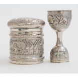 An Indian silver circular pot and cover and a double end measure (2) each chased with village