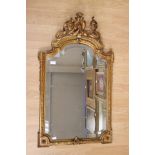 A 19th Century gilt framed pier looking glass of Baroque design, bevelled plate,