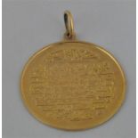 An 18ct. gold Islamic pendant, relief cast obverse with Arabic script, plain reverse stamped ".750",